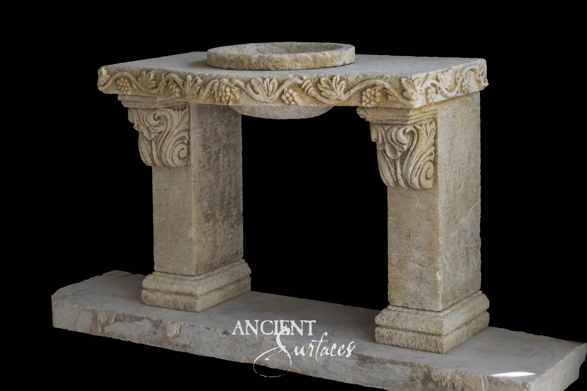 Reclaimed limestone console sink with a carved grapevine frieze along the top, a raised round bowl, acanthus scroll brackets and two square piers on a stone plinth